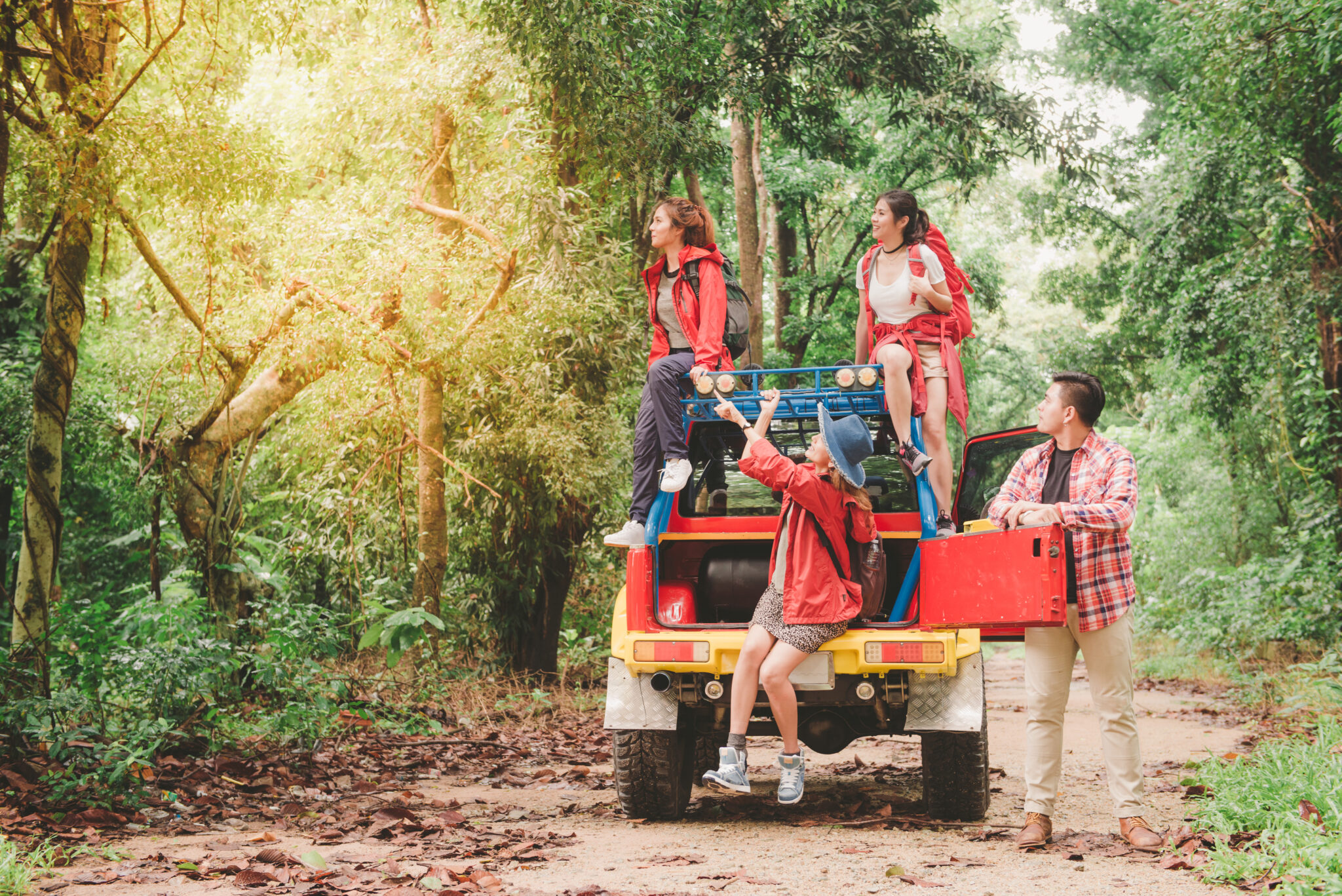 काजीरंगा राष्ट्रीय उद्यान 6 Happy asian young travellers with 4WD drive car off road in forest, young couple looking for directions on the map and another two are enjoying on 4WD drive car. Young mixed race Asian woman and man.